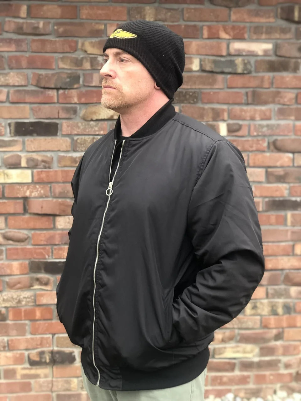 a side profile of a man in the electrum bomber jacket
