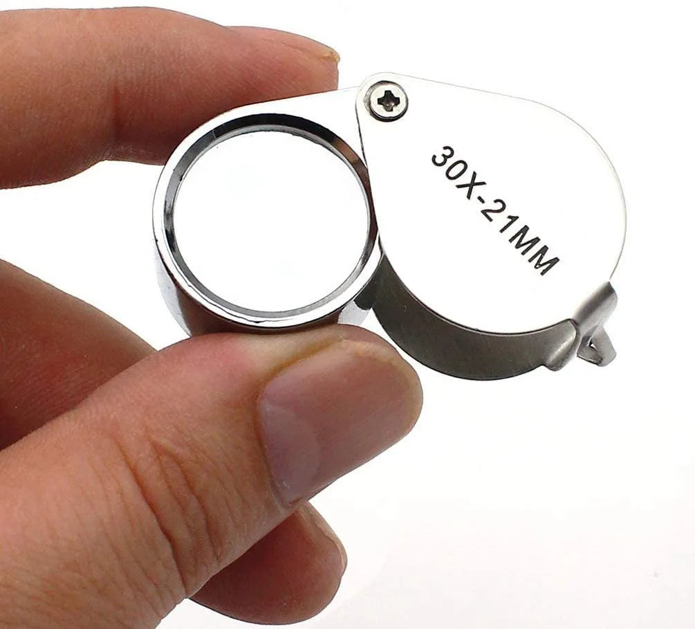hand holding magnifying glass showing actual size