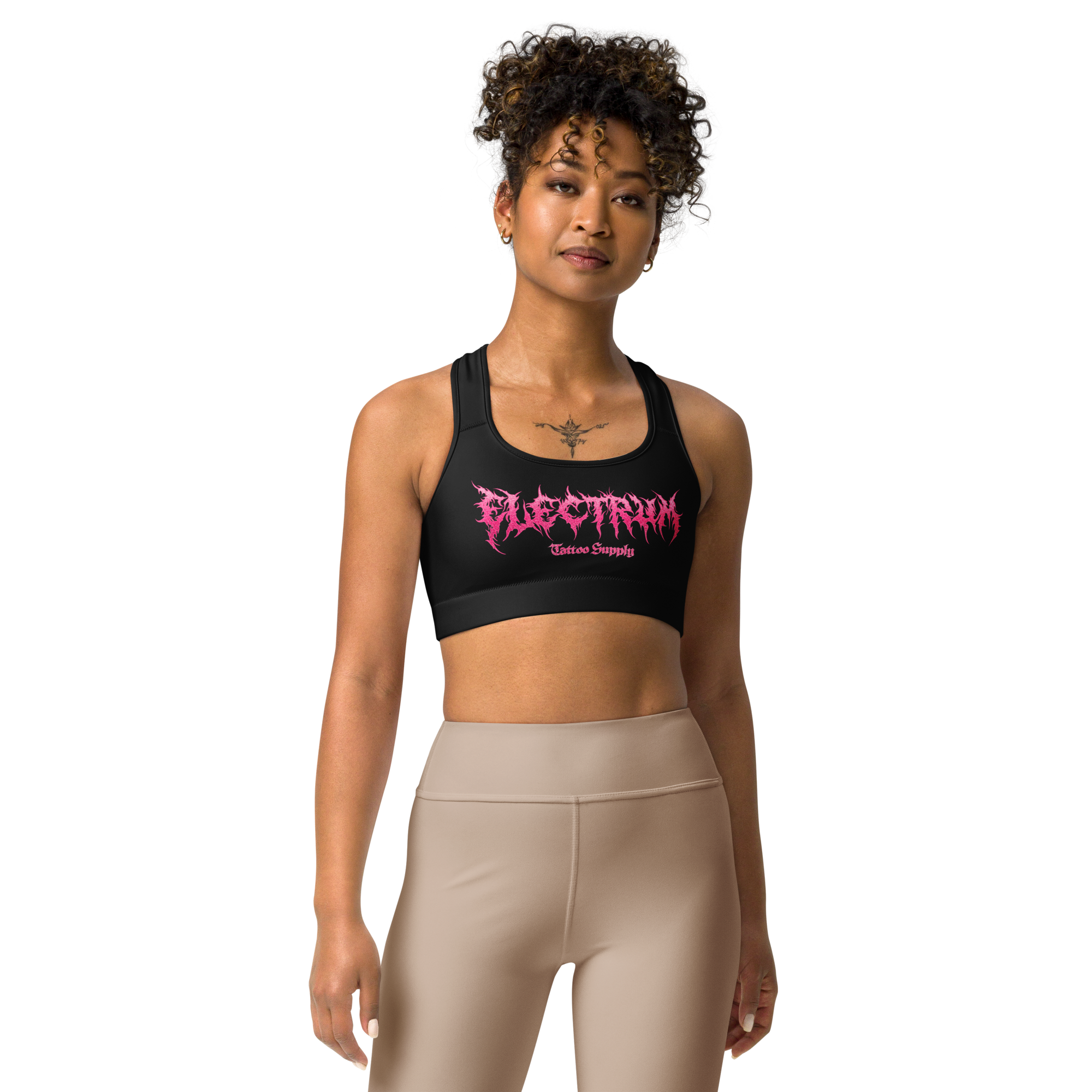 Woman wearing a black sports bra with pink metal lettering saying electrum tattoo supply