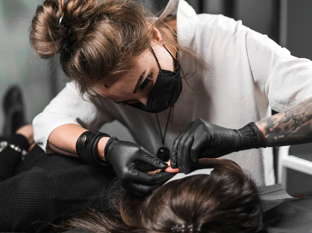 Female body piercer doing an ear piercing