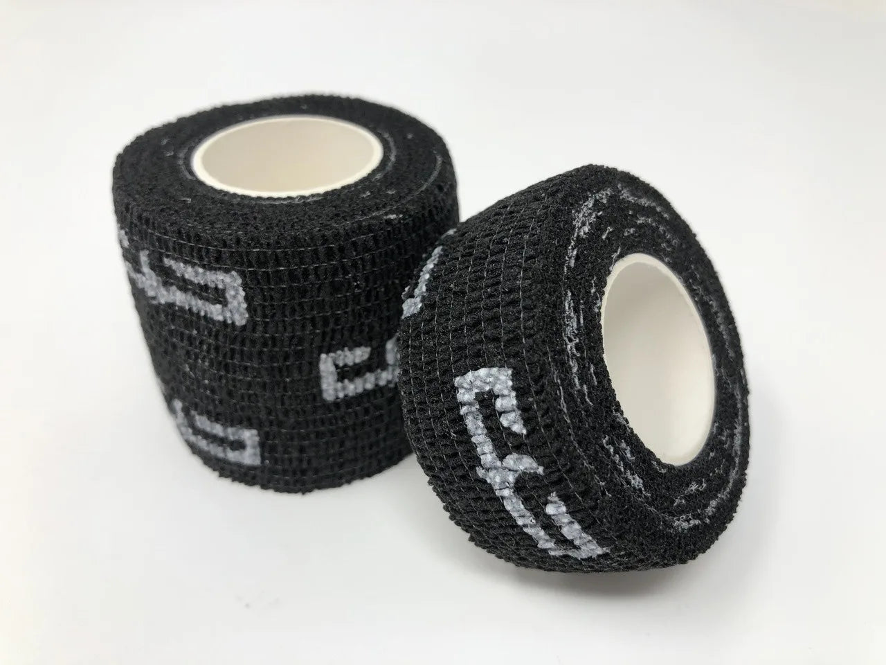 Two rolls of black cohesive wrap grip tape with the Electrum brand logo visible