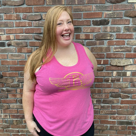 someone wearing a pink electrum tank top with gold lettering 
