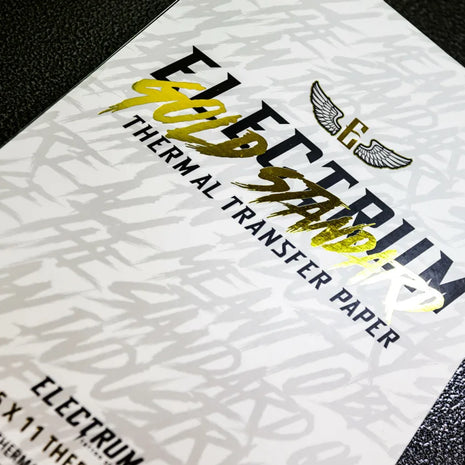 A close-up of a sheet of Electrum Gold Standard Thermal Transfer Paper with a tattoo design, indicating the paper's use for transferring patterns onto skin.