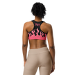 Person wearing a pink and black sports bra with flames and a fire cartridge logo on back