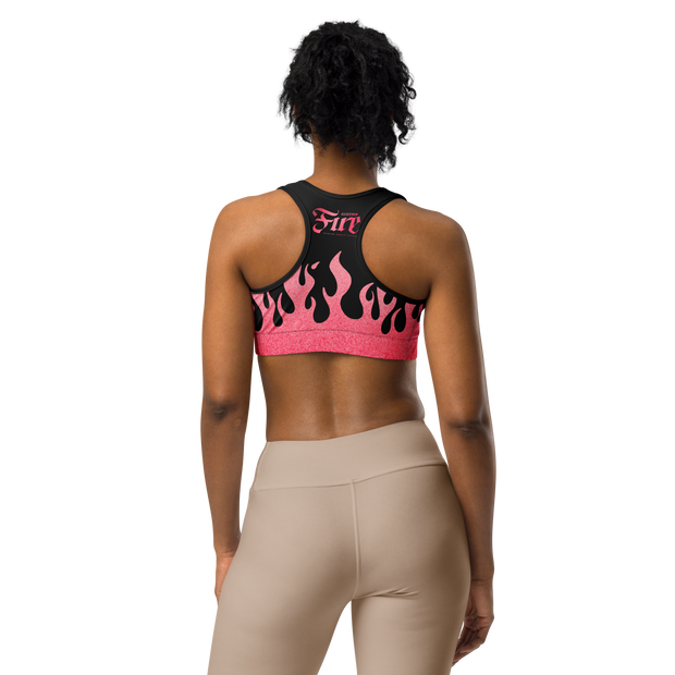 Person wearing a pink and black sports bra with flames and a fire cartridge logo on back