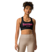 Woman wearing a black sports bra with pink metal lettering saying electrum tattoo supply