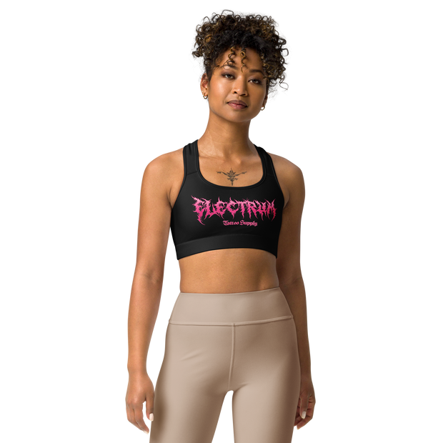 Woman wearing a black sports bra with pink metal lettering saying electrum tattoo supply